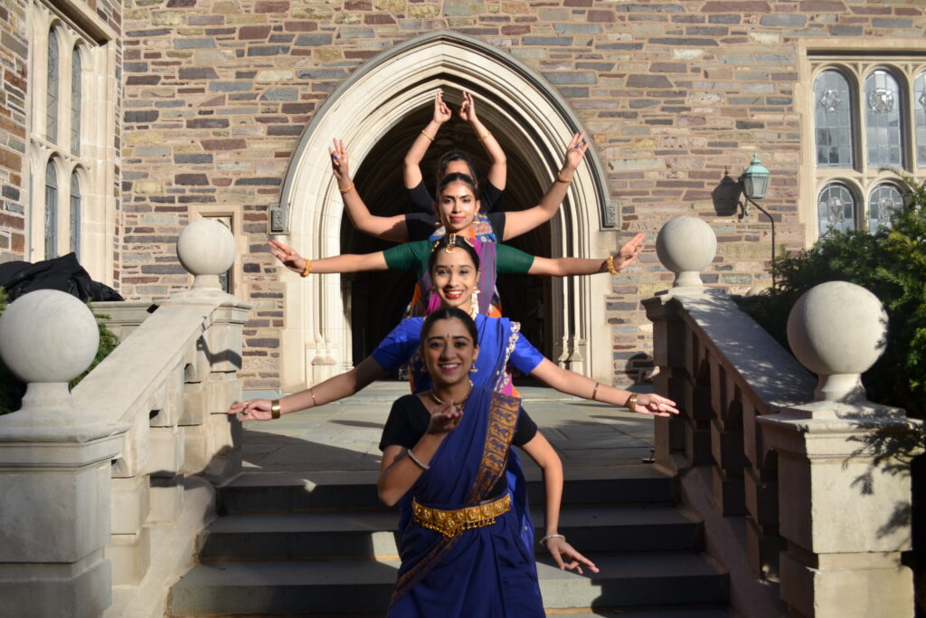 four dancers showing a peacock