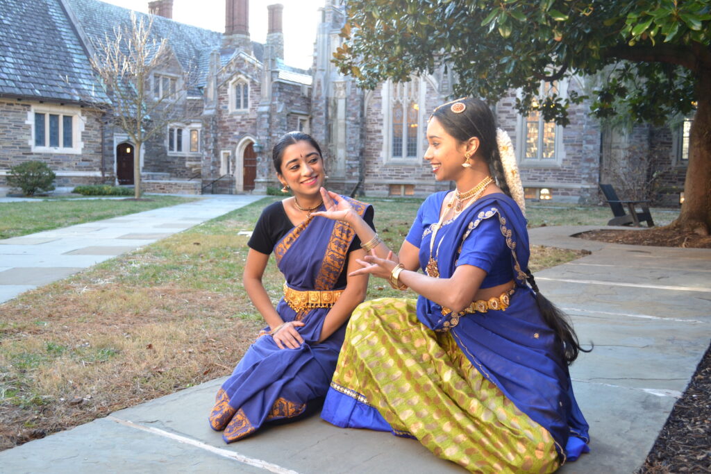two dancers posing as yashoda feeding little krishna butter