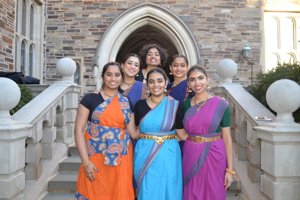6 dancers smiling at the camera on the stairs